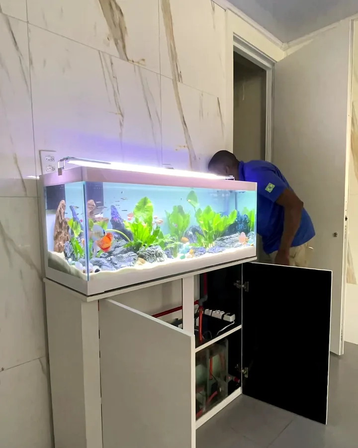Técnico ajustando o filtro no móvel do aquário, na obra