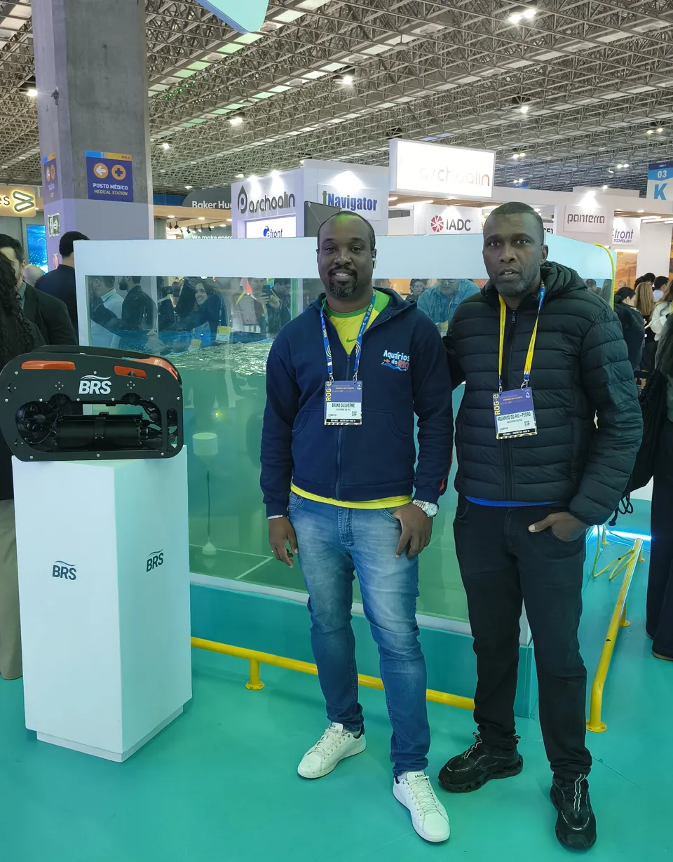 Dois membros da equipe da Aquários do Rio, de crachá, em frente ao tanque na ROG.e 2026